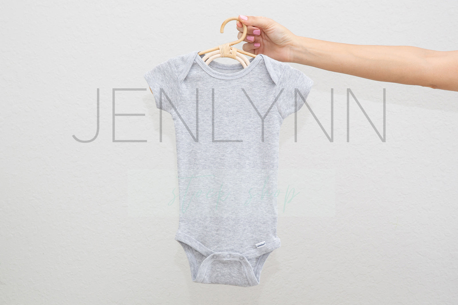 Woman Holding White Onesie on hanger Mockup #4 JPG