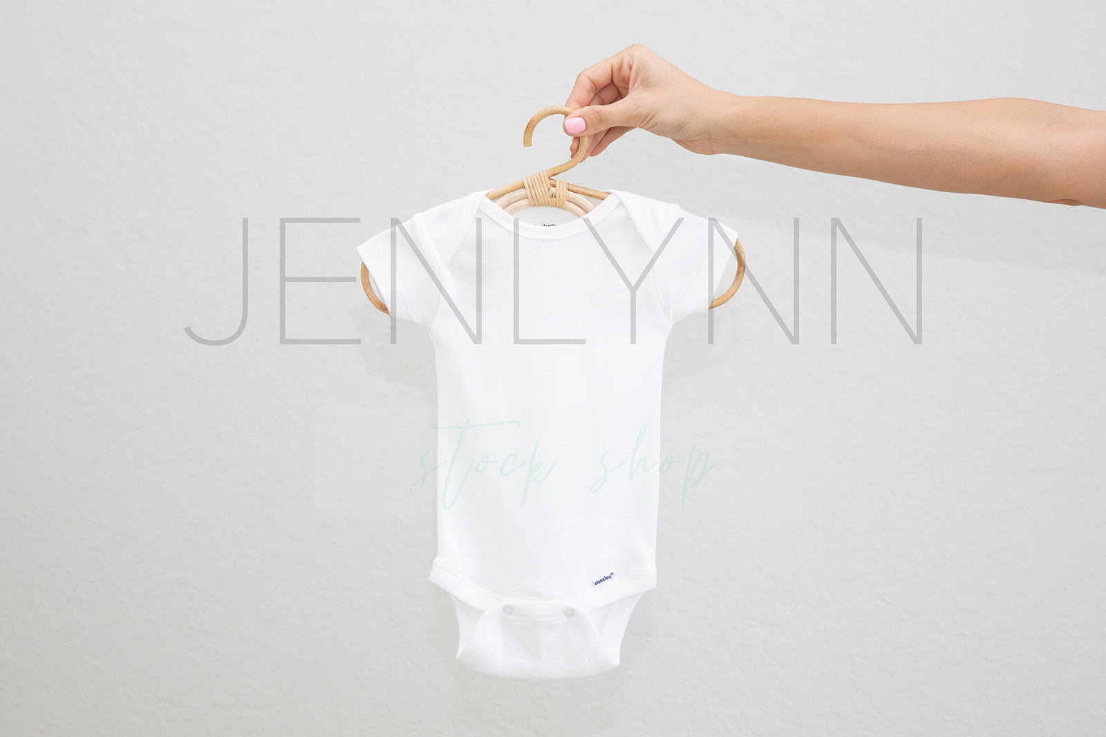 Woman Holding White Onesie on hanger Mockup #5 JPG